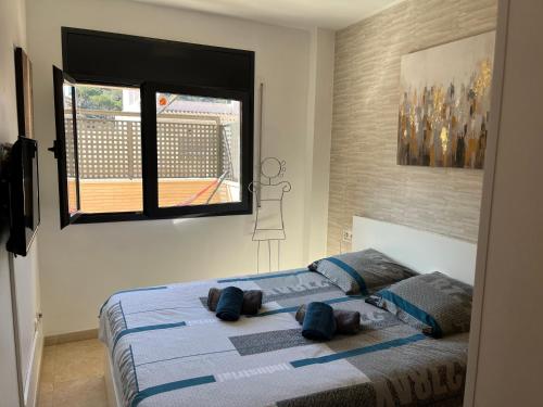 a bedroom with a bed with blue sheets and a window at Appartement standing 58m plage à 3mn en voiture in Roses