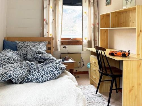 Un dormitorio con una cama y un escritorio con un coche de juguete. en Holiday home Austefjorden, en Austefjorden