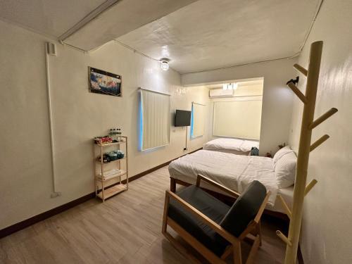 a bedroom with a bed and a chair in it at 鰆居Chun House 三仙台 in Chenggong