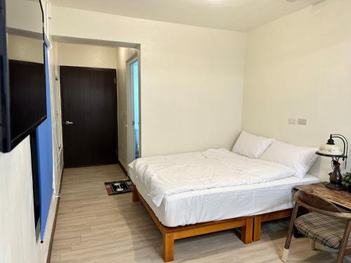 a bedroom with a bed and a door to a room at 鰆居Chun House 三仙台 in Chenggong
