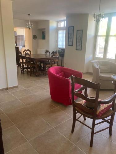 un salon avec un canapé rouge et une table dans l'établissement Maison place champs de foire 6 pers 3 chambres jardin terrasse, à Chamberet