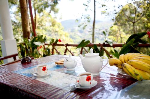 a table with tea cups and bananas on it at " YOLO " LOVELY COTTAGE in Ella