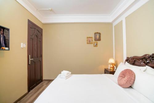 a bedroom with a large white bed and a door at SAZI BEN THANH Hotel HCM in Ho Chi Minh City