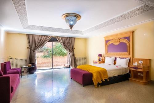 - une chambre avec un lit et deux chaises violettes dans l'établissement Villa marrakech, à Marrakech