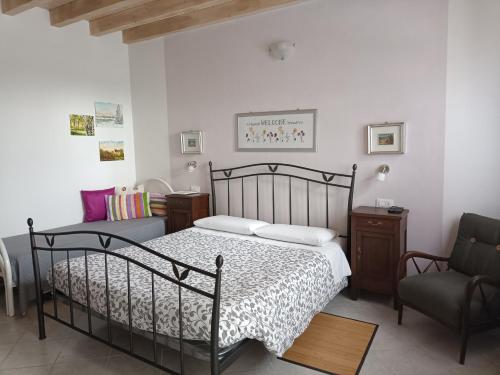- une chambre avec un lit et une chaise dans l'établissement B&B La Casarella, à Soiano del Lago