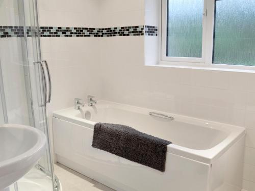 a white bath tub in a bathroom with a window at West View in Sturminster Marshall
