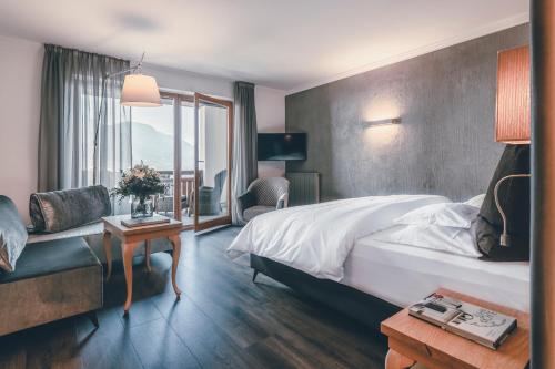 ein Hotelzimmer mit einem Bett, einem Tisch und einem Sofa in der Unterkunft Golserhof in Dorf Tirol
