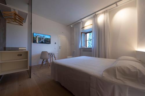 a white bedroom with a bed and a window at Terra d'Ombra Bed&Breakfast in San Gimignano