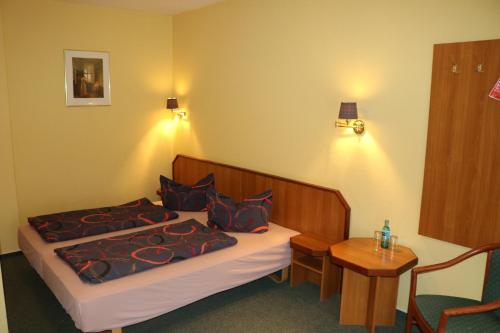 a hotel room with a bed and a table at Stadthotel Brandenburger Hof in Neuruppin