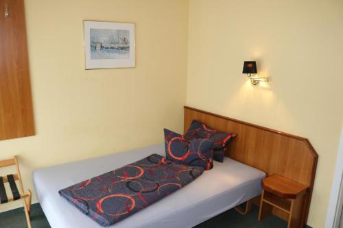 a bedroom with a bed with a blue comforter at Stadthotel Brandenburger Hof in Neuruppin