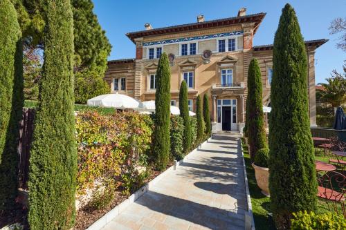 uma mansão com árvores em frente em Hôtel Particulier Château Beaupin by Territoria em Marselha