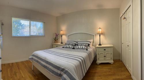 sypialnia z łóżkiem, 2 szafkami nocnymi i oknem w obiekcie Aileen Full House w mieście Delta
