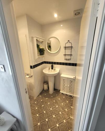 a bathroom with a sink and a mirror at Willesden, Flat 2, A 1 Bedroom flat right in the heart of Llandudno in Llandudno