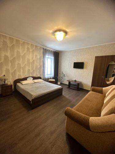 sypialnia z łóżkiem i kanapą w obiekcie Vesela Bdzhilka w mieście Sumy