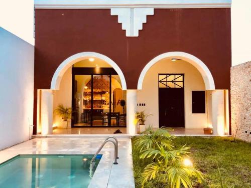 a house with a swimming pool in front of a building at Casa Valentina: lovely house in downtown Merida in Mérida