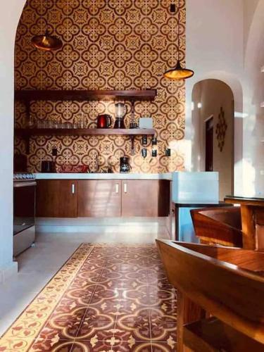 a large kitchen with a counter and a kitchenasteryasteryasteryasteryasteryasteryastery at Casa Valentina: lovely house in downtown Merida in Mérida