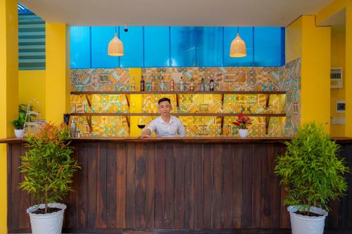 a man standing behind a bar in a restaurant at Hoi An Heart hostel Villa - Bespoke in Hoi An