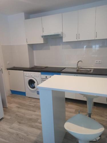 een witte keuken met een wastafel en een wasmachine bij APARTAMENTO BAJO ALCOBENDAS in Alcobendas