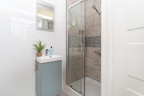 a bathroom with a shower and a sink and a toilet at Stunning Views Over Mounts Bay with Balcony in Penzance