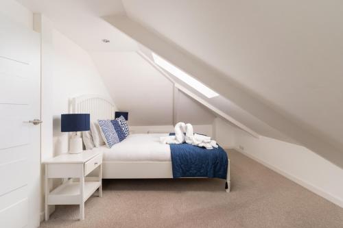 a white bedroom with a bed and a desk at Stunning Views Over Mounts Bay with Balcony in Penzance