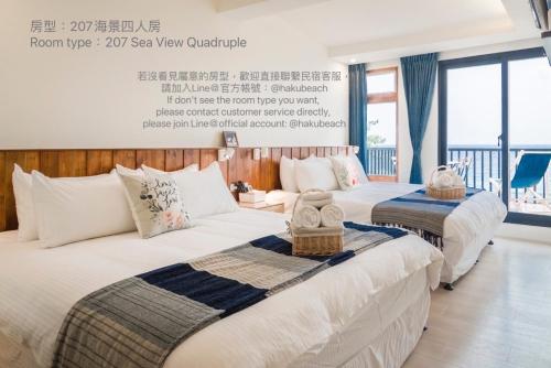 2 camas en una habitación de hotel con un cartel en la pared en Chuanfanrock Haku Beach Days Inn, en Eluan