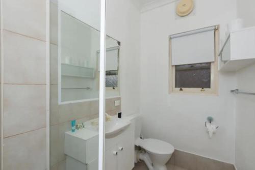 a white bathroom with a toilet and a sink at M104 West Perth Studio Apartment near Kings Park in Perth