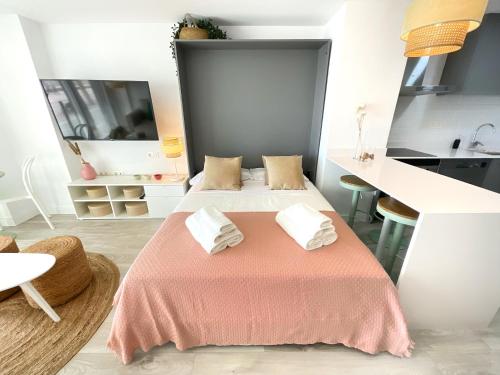 1 Schlafzimmer mit 2 Betten und einer rosa Tagesdecke in der Unterkunft CS7 Kaleria Suites in Almería
