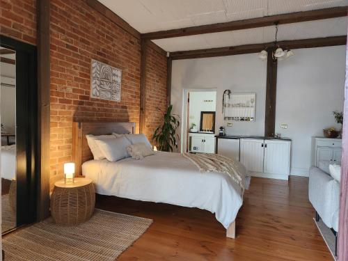 a bedroom with a bed and a brick wall at Marananga Cottages in Marananga