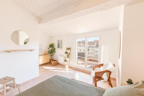 Elle comprend un salon avec des murs blancs et une grande fenêtre. dans l'établissement Charmant Dupleix,toit terrasse, à Toulon