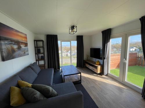 a living room with a blue couch and a tv at Zee en duin in IJmuiden