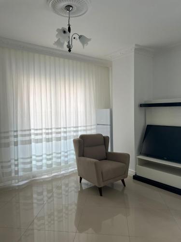 a living room with a chair and a television at Lägenhet i Yekta Sobieski Development in Alanya