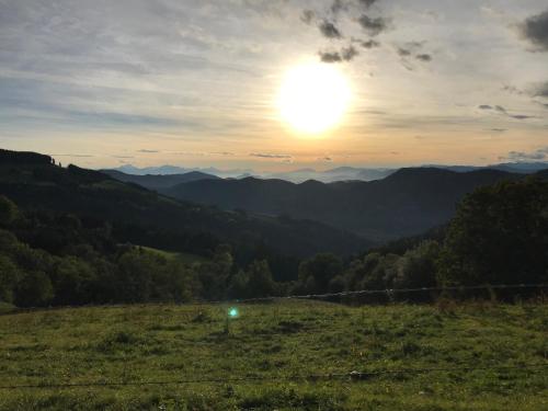 a sunset in a field with the mountains in the background at Familienbauernhof Gunzer-Sank in Eberstein