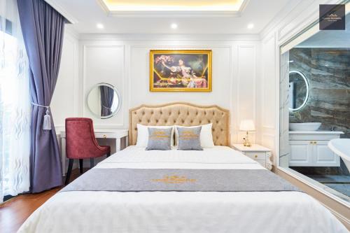 - une chambre avec un grand lit et une chaise rouge dans l'établissement Luxury Homestay Vinhomes Dragonbay Hạ Long, à Hạ Long