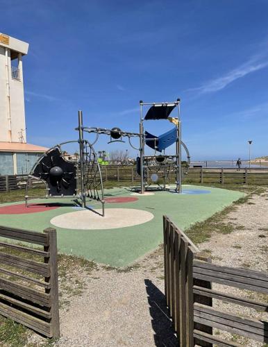 un parc avec une aire de jeux et une balançoire dans l'établissement Appartement Front de Mer à Saint Pierre La Mer 4PAR14, à Saint Pierre La Mer