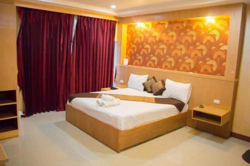 a bedroom with a bed with a painting on the wall at new pind balluchi inn in Pattaya