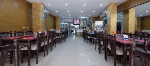 a dining room with tables and chairs in a restaurant at new pind balluchi inn in Pattaya