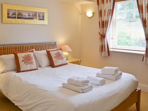 una camera da letto con un letto bianco e asciugamani di High Mere a Windermere