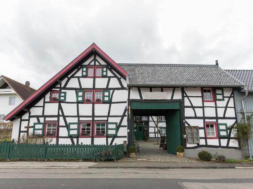 a black and white building with a green gate at Vintage Apartment with Garden in Schleiden