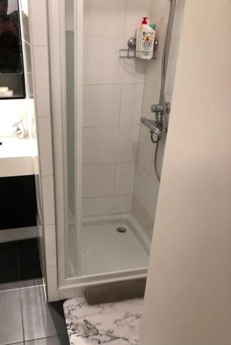 une douche avec une porte vitrée dans une salle de bain dans l'établissement Cosy studio situé en plein cœur du vieil antibes., à Antibes