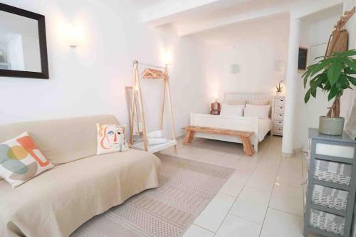 un salon blanc avec un canapé et une table dans l'établissement Cosy studio situé en plein cœur du vieil antibes., à Antibes