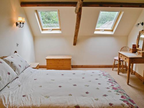a bedroom with a bed and two windows at Nightingales in Kentisbeare