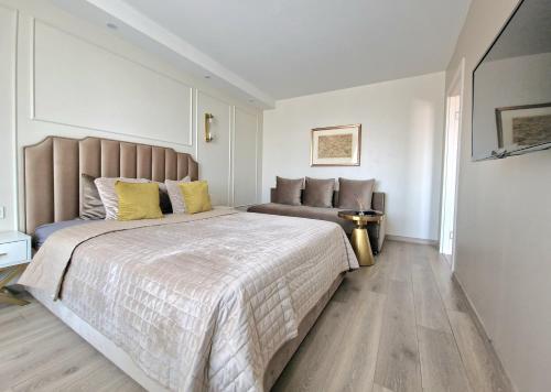 1 dormitorio con 1 cama grande con almohadas amarillas en Vanilės apartamentai, en Klaipėda