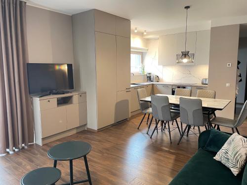 a living room with a table and chairs and a kitchen at Tulbi Apartment in Pärnu