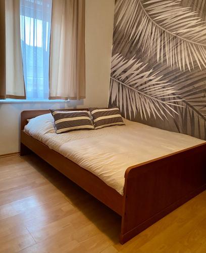 a bed with two pillows on it in a bedroom at Apartmani HILA in Njivice