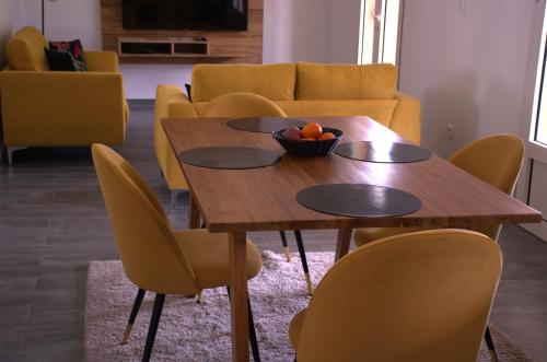 una mesa con sillas y un bol de fruta en ella en Villa Le Jacaranda en Salazie