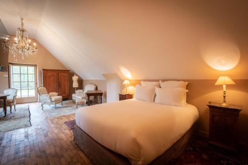 a bedroom with a large white bed in a room at Domaine de Charnay Villégiature Sologne in Vierzon