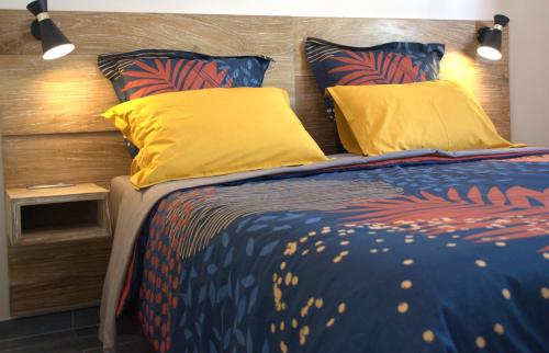 a bedroom with a bed with yellow pillows at Villa Le Jacaranda in Salazie