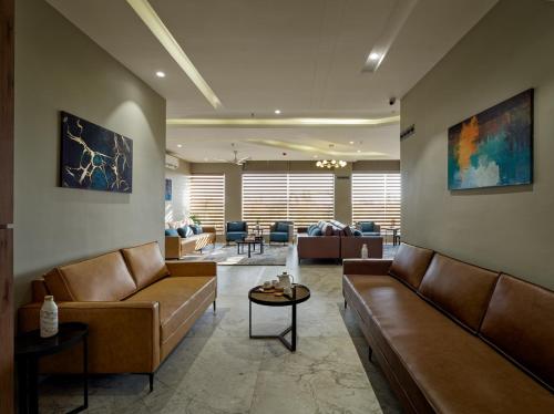 a lobby with brown leather couches and chairs at Hotel Akruti, Nanded in Nānded