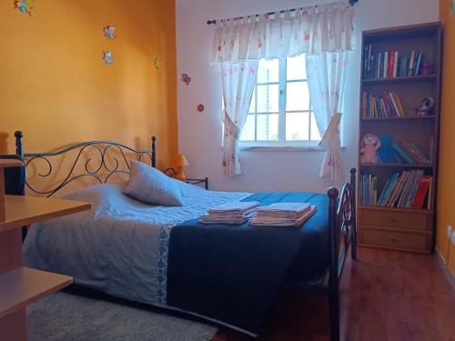 Un dormitorio con una cama azul y una ventana en Alojamento local Família Coelho en Quinta do Conde
