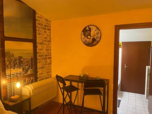 ein Zimmer mit einem Tisch und Stühlen sowie einer Uhr an der Wand in der Unterkunft Stenghe Stracche in Ascoli Piceno